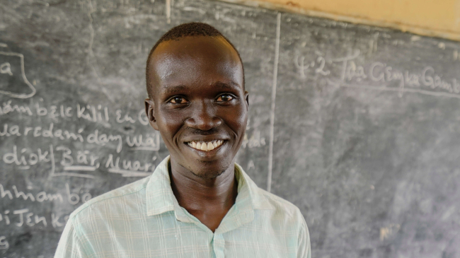 Teacher in front of a black board in Ethiopia. For more information, watch "We teach here" https://www.facebook.com/watch/?v=4504774522959407